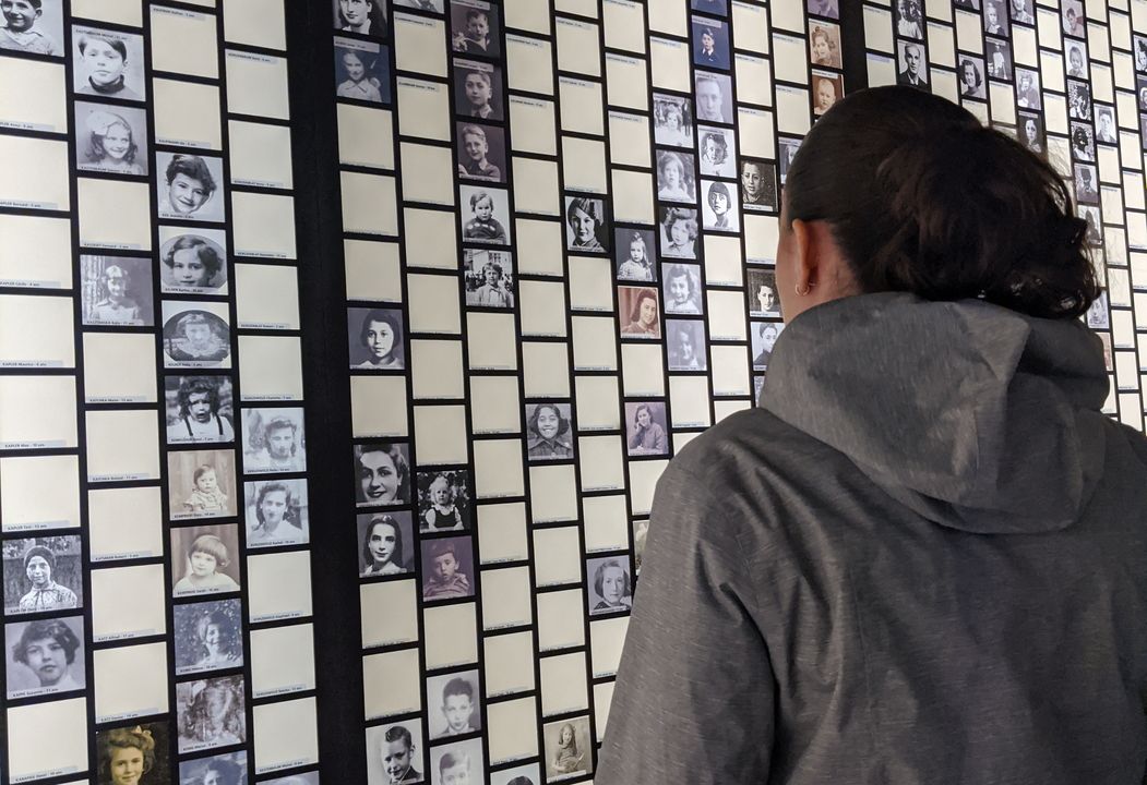 Eine Frau sieht auf eine Wand voller Fotos